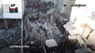 Rescuers search the rubble after a building collapse in Latakia, Syria, kills at least 16 people.