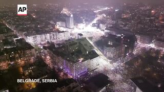 Phones glow in night at silent anti-government protest in Serbia.