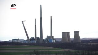Smokestacks of former coal-fired power plant crumble in planned demolition.