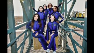 The crew members are wearing designer spacesuits