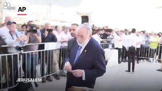 Mike Huckabee places note from Trump in Western Wall in Jerusalem.