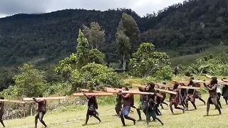 The Dem tribe community lifts foundation wood from the top of the mountain to the school site, Its purpose is to build an elementary school building.