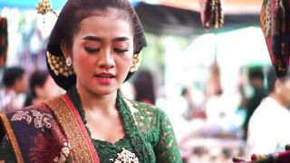 Beautiful Indonesian girl selling traditional clothes