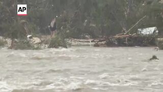Fast moving flood waters from Guadalupe River rush over road in