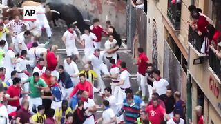 Spectators watch people running with bulls at the San Fermín