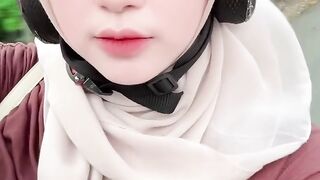 Beautiful Indonesian hijab girl riding a motorbike