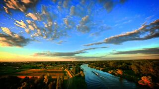 A Serene Day with Blue Skies, Trees All Around, and a Calm River Flowing