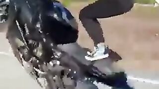 Beautiful girl one wheeling on motorcycle
