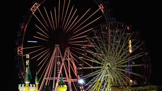 Two Ferris Wheels at an Amusement Park at Night