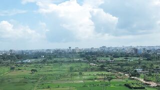 The blue sky with clouds and vast green fields