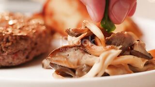 Close up of delicious grilled beef steak medallions served on table with potato and mushrooms, adding green onion