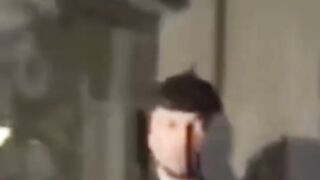 Andrew Tate holds the Quran while walking into court