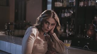 woman sitting at a bar with a drink