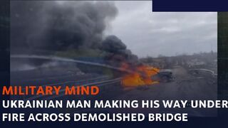 Ukrainian man making his way under fire across demolished bridge
