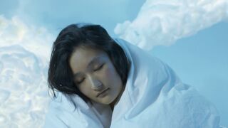 A Woman Covered With Blanket Seriously Looking at Camera