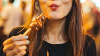 Beautiful Girl Enjoys Juicy Skewers at Night Market