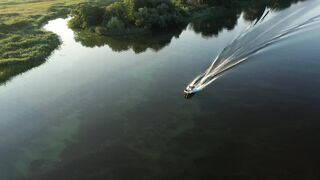 A small boat is crossing the river