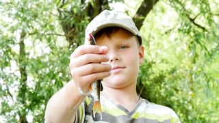 A child is showing a fish in his hand