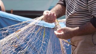 An old man is pulling a net