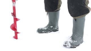 Someone is drilling a hole in the ice-covered lake.