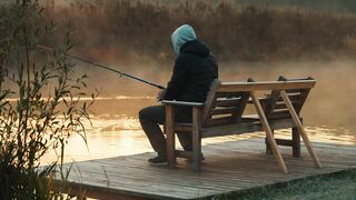 A person is sitting fishing in the lake