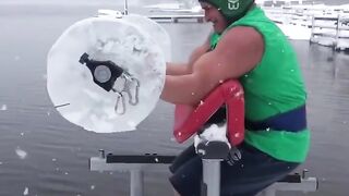 A man does barbell exercises outside during a snowfall