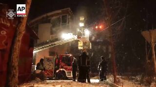 Ukrainian firefighters respond to Russian strike as snow falls.