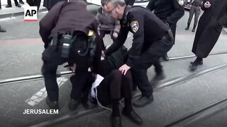 Jerusalem police drag ultra-Orthodox Jewish men protesting military enlistment.