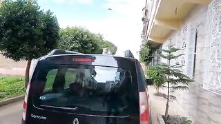 The cute cat sitting on top of the car wants food from me.