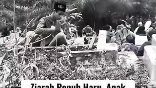 A child next to his parents' grave is speaking in sign language
