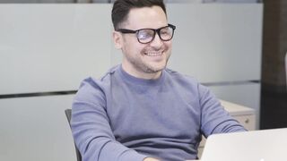 Notes on Being a Man - a man working with a laptop while talking with a peer | Trending HD Vide