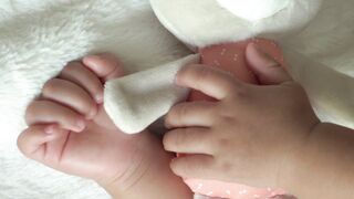 Babymoov - adorable baby holding toy bear on soft blanket | Trending HD Video
