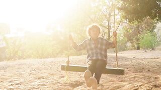 Action figure - a boy swinging on a swing under the tree | Trending HD Video