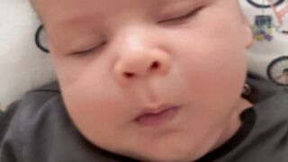 Baby Toys - a baby boy in a batman shirt is laying on a bed | Trending HD Video