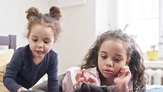 Kids Petting Their Cat On The Bed