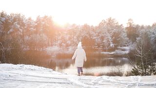 Woman - a woman walking towards a frozen lake | Trending HD Video