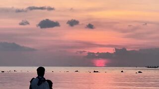 Travel Backpack - two people standing in the water at sunset | Trending HD Video