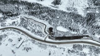 Woman Within - aerial footage of a forest road in a snowy landscape | Trending HD Video