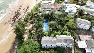 Travel Backpack - aerial view of coastal town with beach and buildings | Trending HD Video