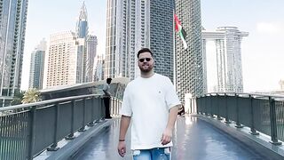 travelite - man walking near iconic skyscraper in dubai | Trending HD Video