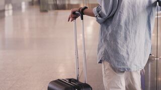 Travelon - person holding his luggage | Trending HD Video