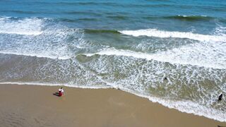 Travelon - serene beach aerial view with waves and visitors | Trending HD Video