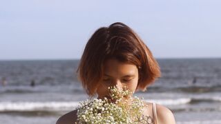 Wonder Woman - shallow focus of woman smelling the white flowers while smiling | Trending HD Vi