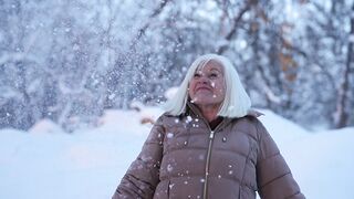 Winter Coat - joyful senior woman enjoying winter snowfall | Trending HD Video