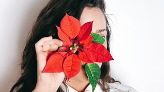 The Shy Snow Woman and the Cursed Ring - a woman posing with a red flower covering her face | T
