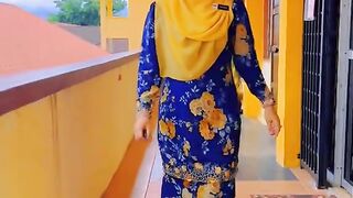Woman in Blue and Yellow Floral Dress Walks Down a Vibrant Hallway
