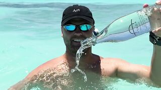 Travelon - man enjoying tropical beach with water bottle | Trending HD Video