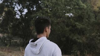Funnyfuzzy - a young man in a grey hoodie standing in a field | Trending HD Video