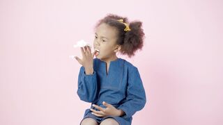 Funny Gift Ideas - a little girl blowing her nose on a pink background | Trending HD Video