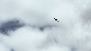 Travelon - an airplane flying in a cloudy sky | Trending HD Video